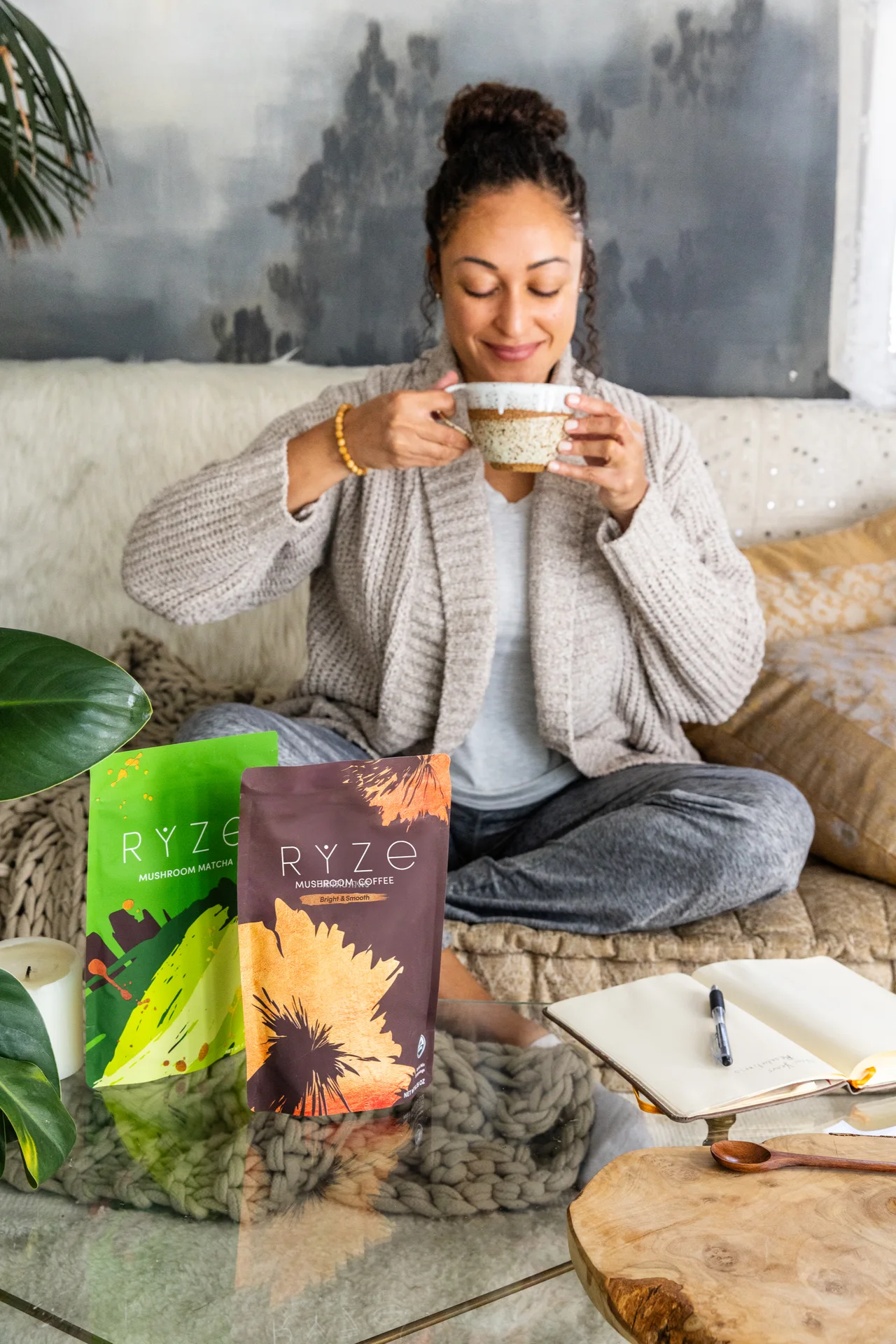 Woman sitting with a warm mug of RYZE mushroom coffee and her journal
