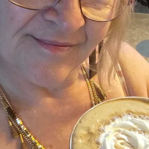 Customer cheering at her kitchen table with her mug and RYZE starter box