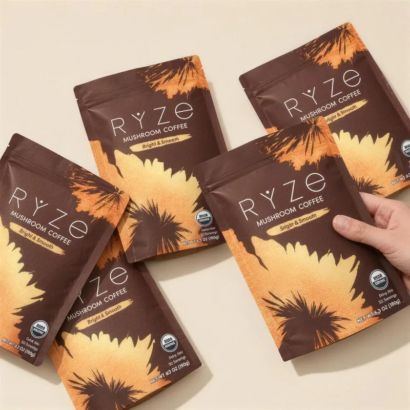 Four pouches of RYZE Mushroom Coffee laid out, one lifted by hand