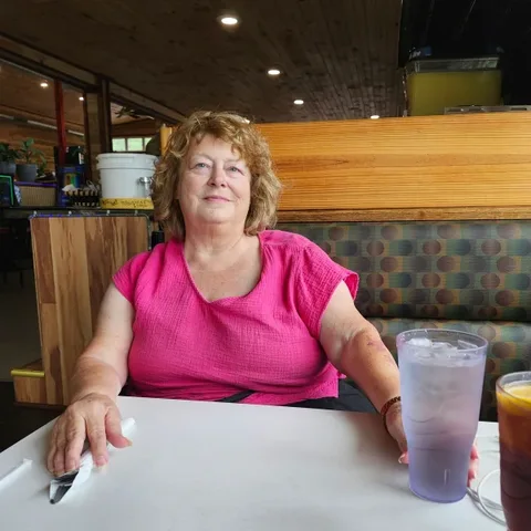 Customer in glasses sipping RYZE from her orange tumbler