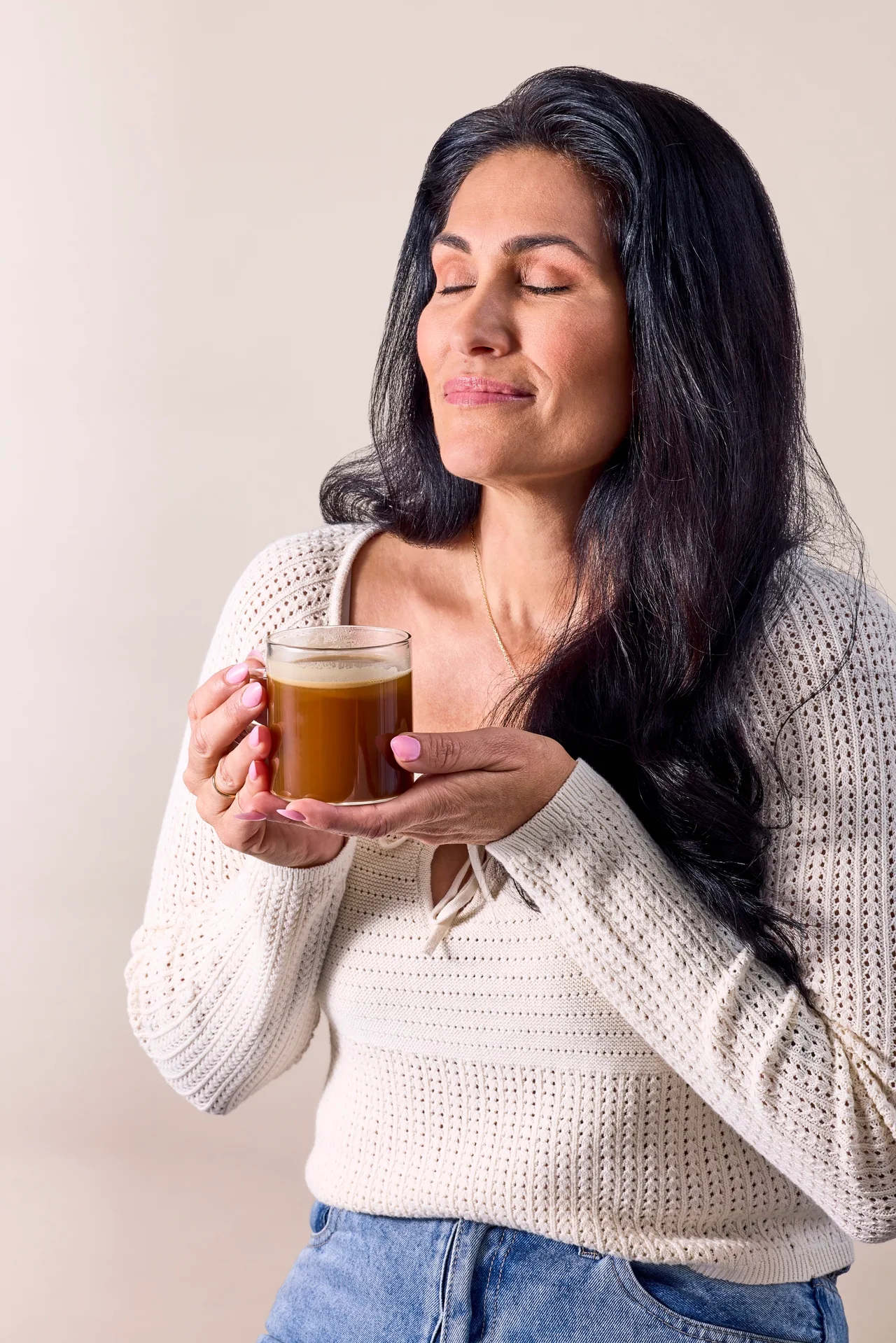 Woman with her eyes closed, savouring a creamy cup of RYZE mushroom coffee