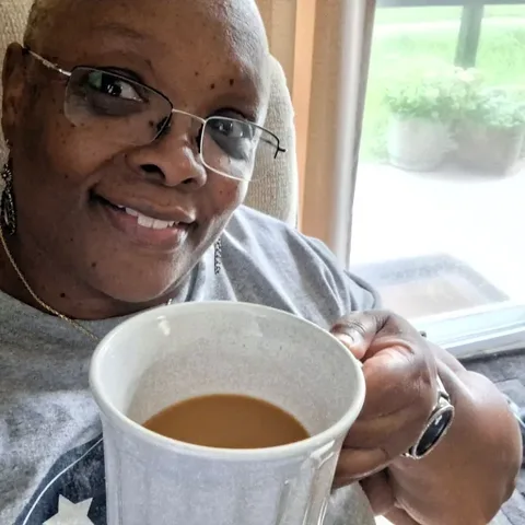Customer with a white beard sipping his morning RYZE from a flower mug