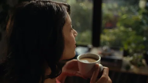 Woman pausing with a warm mug of RYZE mushroom coffee
