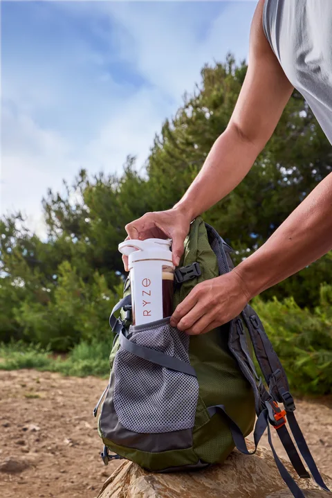 RYZE tumbler tucked into a backpack before a hike