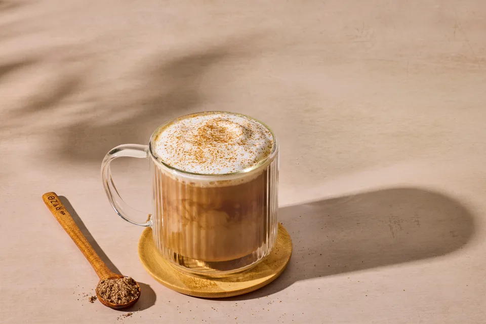 A creamy RYZE mushroom latte in a glass mug