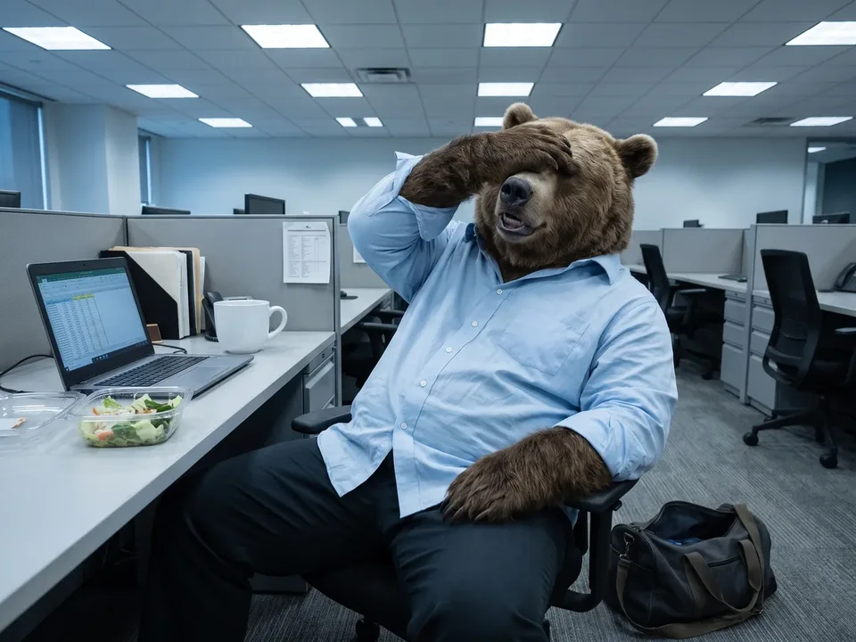 The bear character slumped at his office desk in the afternoon over an oversized plain coffee cup, gym bag on the floor