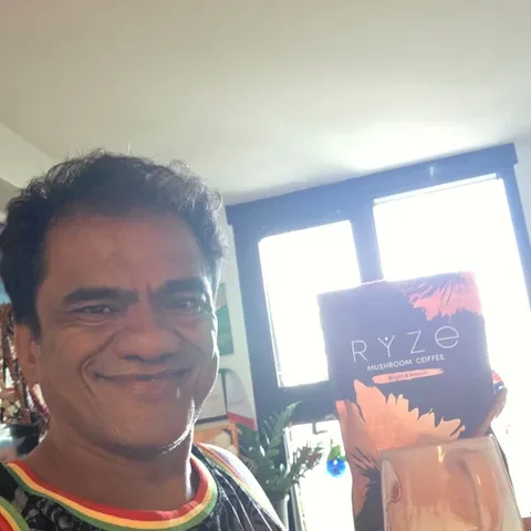 Customer in his work polo holding a bag of RYZE Mushroom Coffee