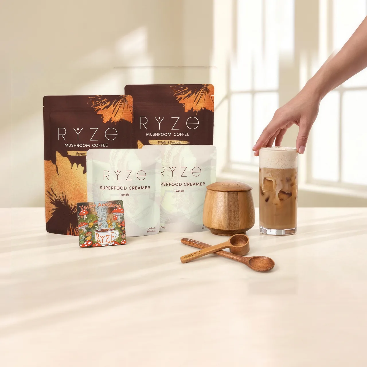 RYZE bundle — mushroom coffee and creamer pouches with a frother jar, scoops, coaster and an iced latte