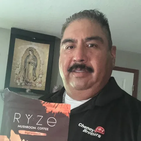 Customer cheering at her kitchen table with her mug and RYZE starter box