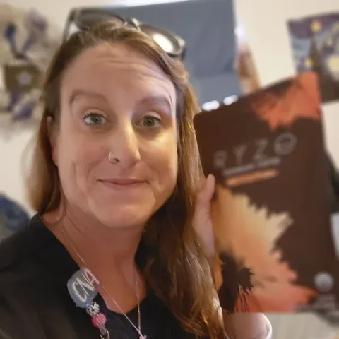 Customer at work holding up her bag of RYZE Mushroom Coffee